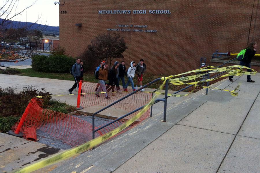 Crumbling sidewalks and steps await repair as Middletown High School students walk around them on their way into school on Nov. 12. The sidewalks were beginning to crack and fall apart and in recent weeks had been blocked off by orange traffic cones. The timeline on when the sidewalk and steps will be completely repaired has not yet been determined.