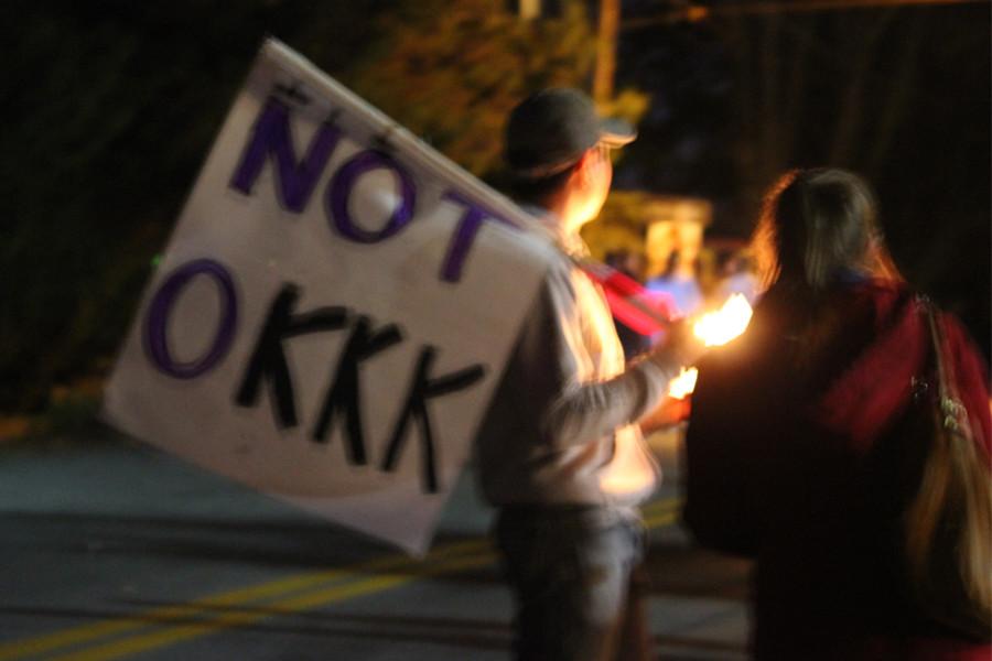 Protestors of the KKK carry creative signs
