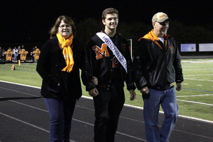 Senior Matt Evich stands with his parents before the homecoming king and queen are announced.